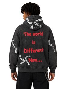 Person wearing a black hoodie with red text and chain designs on a white background