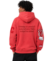 Back view of male model wearing a vintage washed red graphic hoodie with embroidered sleeve patches and oversized streetwear fit against a clean white studio background.